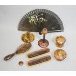 A group of faux tortoiseshell dressing table items and a fan.