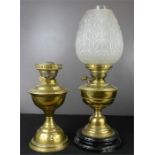 Two Victorian brass paraffin lamp, one with pressed opaque glass shade.