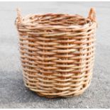 A large wicker log basket, 56cm high by 60cm diameter.