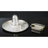 A silver vesta case and a white metal Mexican hat.