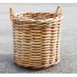 A large wicker log basket, 56cm high by 60cm diameter.