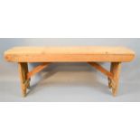 An antique pine bench, with v-cut end boards.