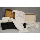 A quantity of antique linen, lace, and other fabric, together with a vintage suitcase.