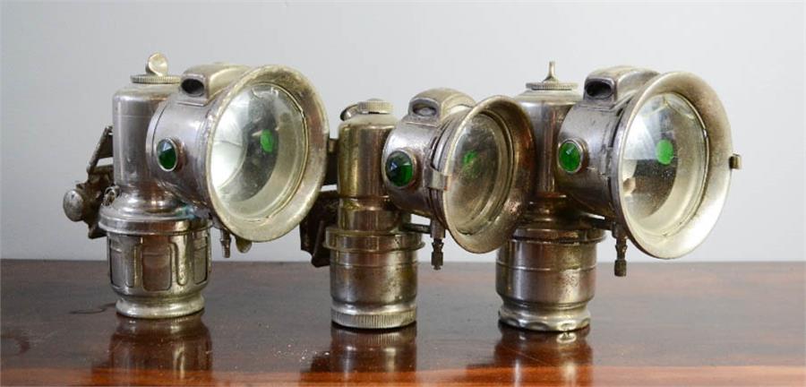 Three vintage bicycle lamps.