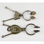 Two Victorian skirt lifters, one with butterfly clip, the other a stylised heart motif.