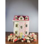 A dolls house together with with John Lewis dolls house furniture.