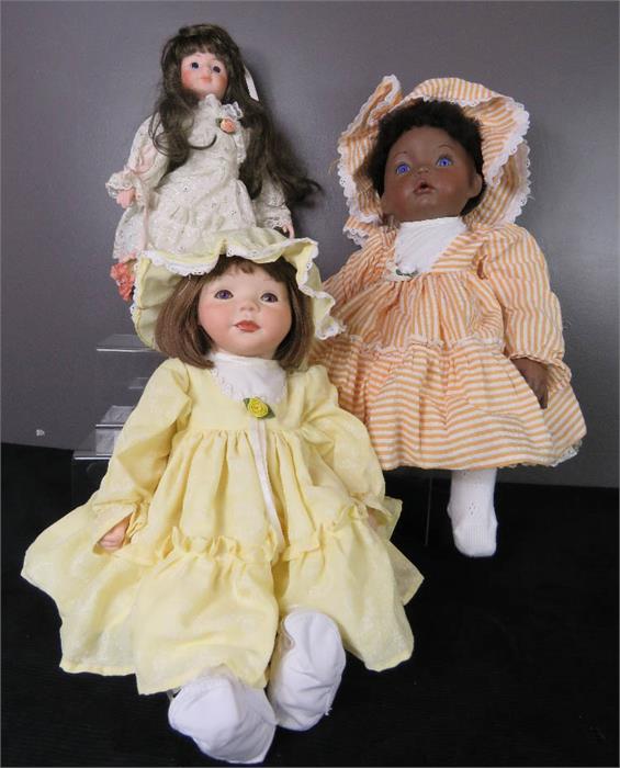 Three porcelain headed dolls, wearing hand made clothes.