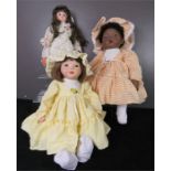 Three porcelain headed dolls, wearing hand made clothes.