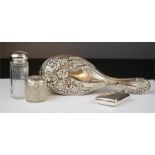 A group of silver to include hair brush, hip flask, and two silver topped dressing table pots.