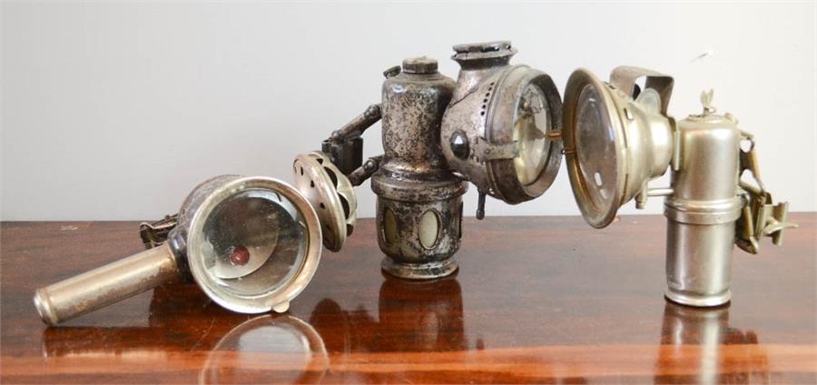 Three vintage bicycle lamps including Scharlach Lampe Nuremberg and other examples.