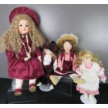 Three porcelain headed dolls, wearing hand made clothes; one competition example wearing Victorian