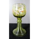 A 19th century green wine glass decorated with enamelled birds and foliage.