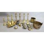 A quantity of brassware, mostly 19th century, including an early pair of brass candlesticks.