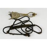 A Victorian brass skirt lifter, with anthemion motif and original cord.