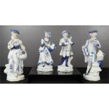 Two pairs of blue and white ceramic figures, in Victorian attire.