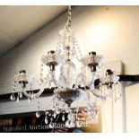 A cut glass five branch chandelier, adorned with various sized drops.