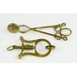 One Victorian and one Edwardian skirt lifter, both in brass.