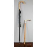 An antique riding crop and an umbrella.