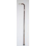 A 19th century walking cane, with silver handle and collar, embossed with scrollwork.