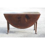 An oak drop leaf table with carved gadrooned edge, the legs terminating on pad feet. [Being sold