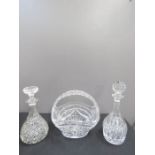 A crystal basket, and two crystal decanters with stoppers.