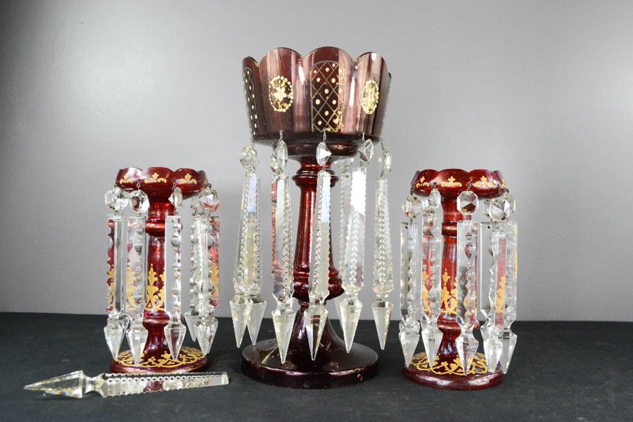 A Victorian red glass lustre, together with a pair of smaller red glass lustres, the highest