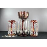 A Victorian red glass lustre, together with a pair of smaller red glass lustres, the highest