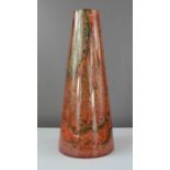 A Vintage conical art glass volcanic vase in orange and red with black splatter effect.