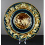 A Majolica charger modelled with cherub scene