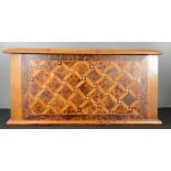 A parquetry box, geometrically inlaid with specimen burr wood and mother of pearl roundels, 27 by 58