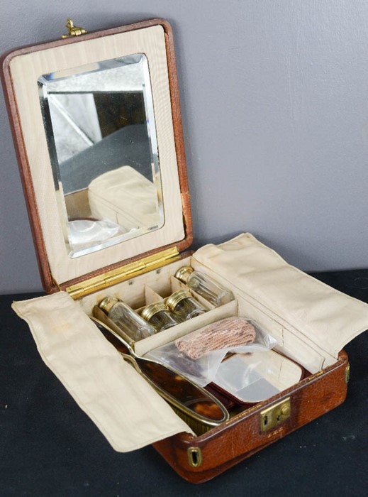 A leather travelling vanity case, by Bruford & Son, Exeter, the compartments containing silver