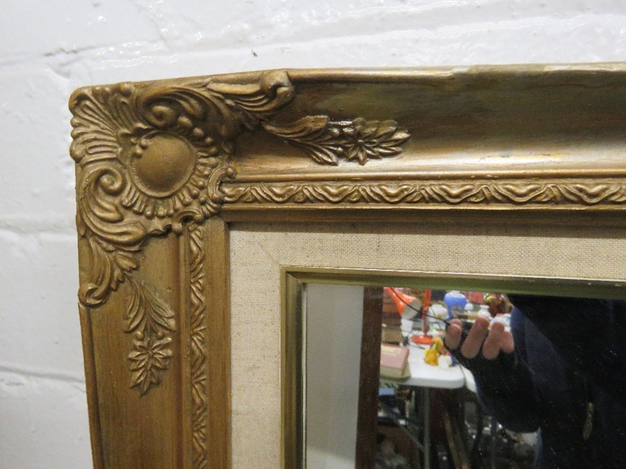 A large wall mirror, gold colored moulded decoration to the corners. - Image 2 of 2