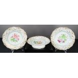 A pair of Victorian ceramic plates and matching comport hand painted with floral studies and