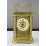 A brass carriage clock together with key.