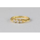 An 18ct gold Edwardian and diamond ring, three stones, size N, 2.8g.