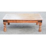 A hardwood coffee table with studs to the top, raised on turned legs, 130 by 90 by 43cm.