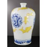 A large Chinese vase depicting yellow fishes and blue and white stylised decoration.