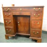 A George III mahogany kneehole desk, with recessed cupboard door flanked by drawers, 80 by 89 by