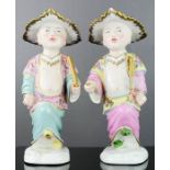 A pair of Meissen Chinese figures of boys, one with yellow shoes, the other green, 23cm high.