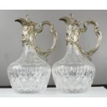 A pair of French silver and cut crystal decanters, the rococo style scrollwork cover, neck and