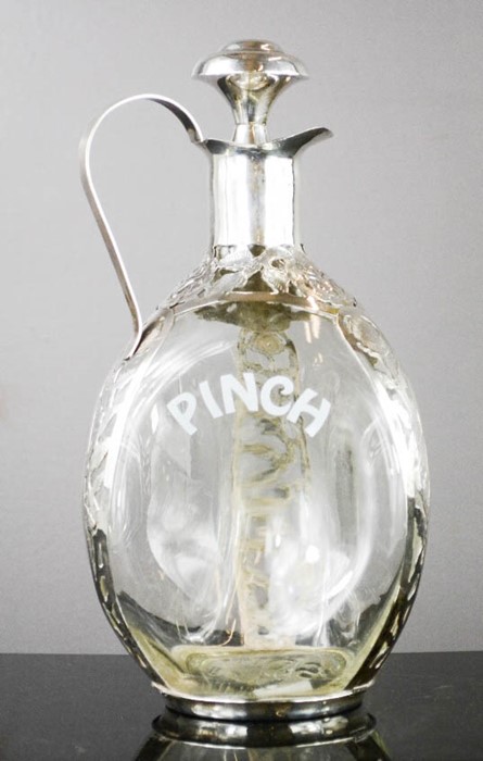 A Pinch decanter with silver mounts and cork top, pierced and engraved with decoration, 24cm high.