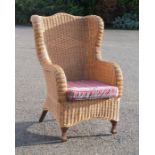 A wicker armchair with cushion seat.