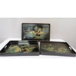 A set of three Japanese graduated black lacquered trays.