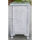 A Lloyd loom three drawer bedside cabinet with hinged closing door.