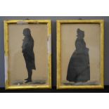 A pair of full length Victorian silhouettes, both in gilded frames.