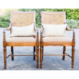 A pair of wicker and mahogany bedroom chairs, with two baluster cushions.