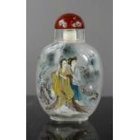 A Chinese glass reverse painted snuff bottle with red jade stopper.