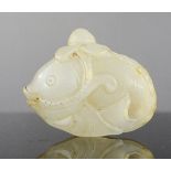 An early Chinese jade carving of a fish, in white with brown striations, 5.5cm long.