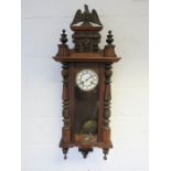 A Vienna wall clock, with gryphon, turned spindles and knobs, and key and pendulum.