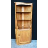 Ercol Golden Dawn corner cabinet with open shelves above single cupboard.